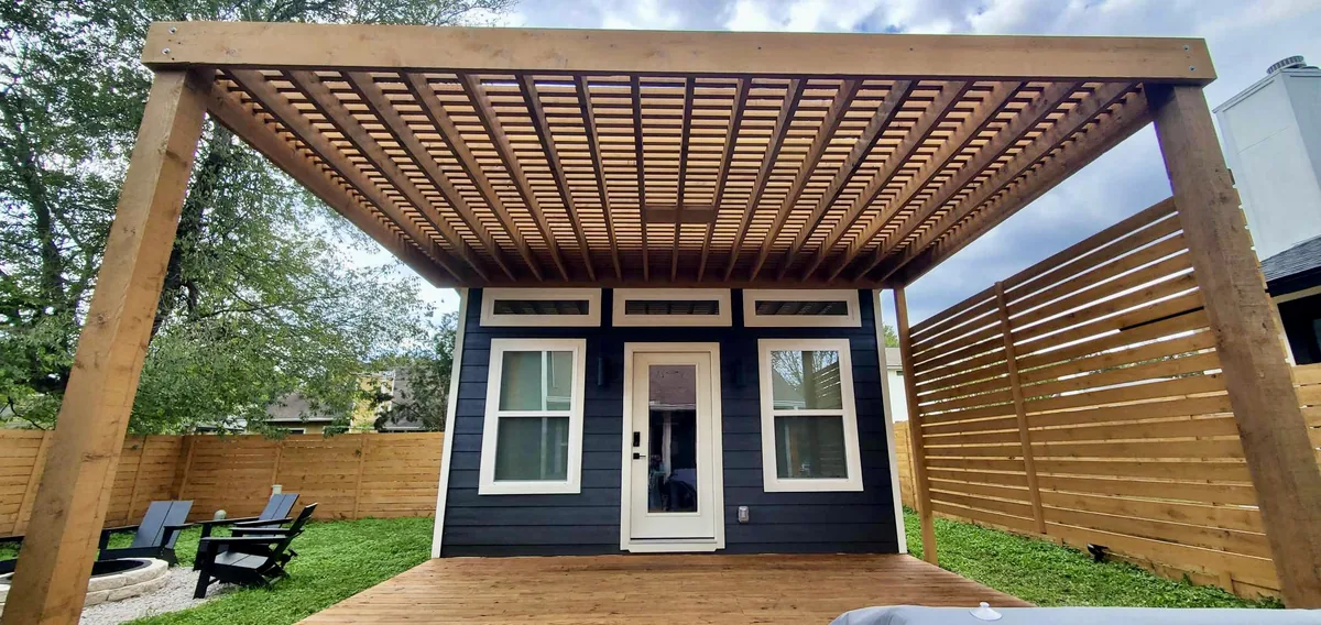 Attached cedar pergola with a privacy wall at a modern home