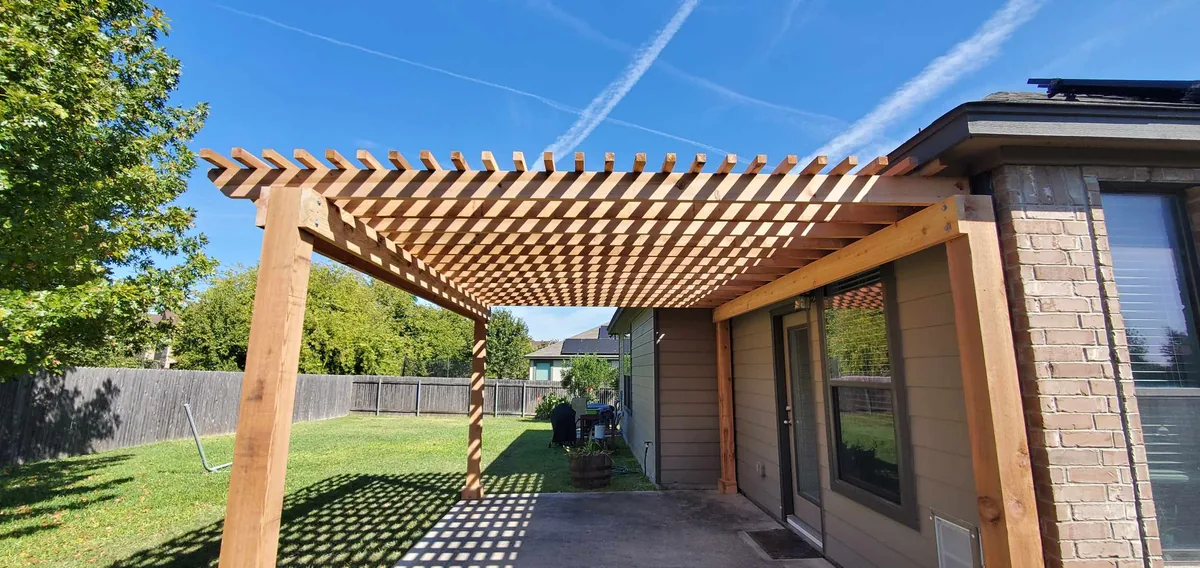 Cedar pergola with a lattice-style top over a concrete patio