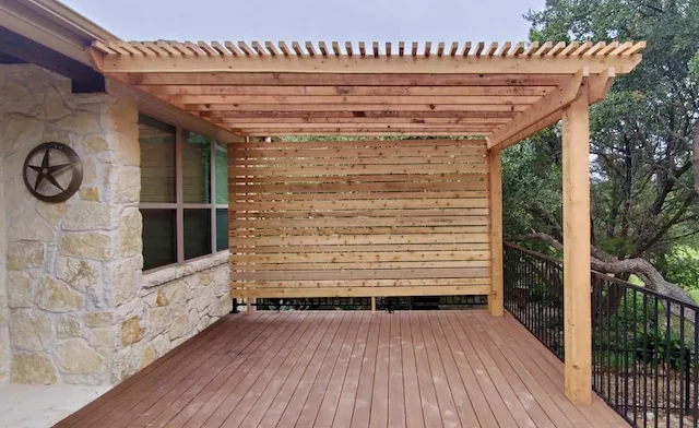 Traditional attached cedar pergola with a privacy wall, built onto a composite deck