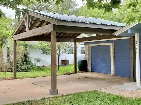 Freestanding gable-style cedar carport with brown stain