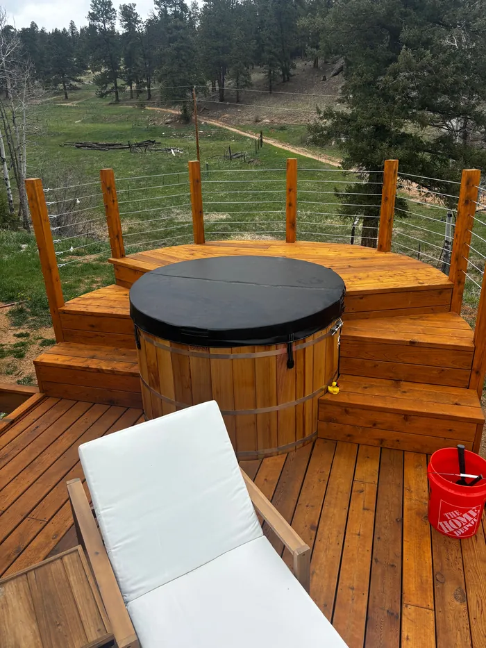 Wraparound deck steps built around a cedar hot tub