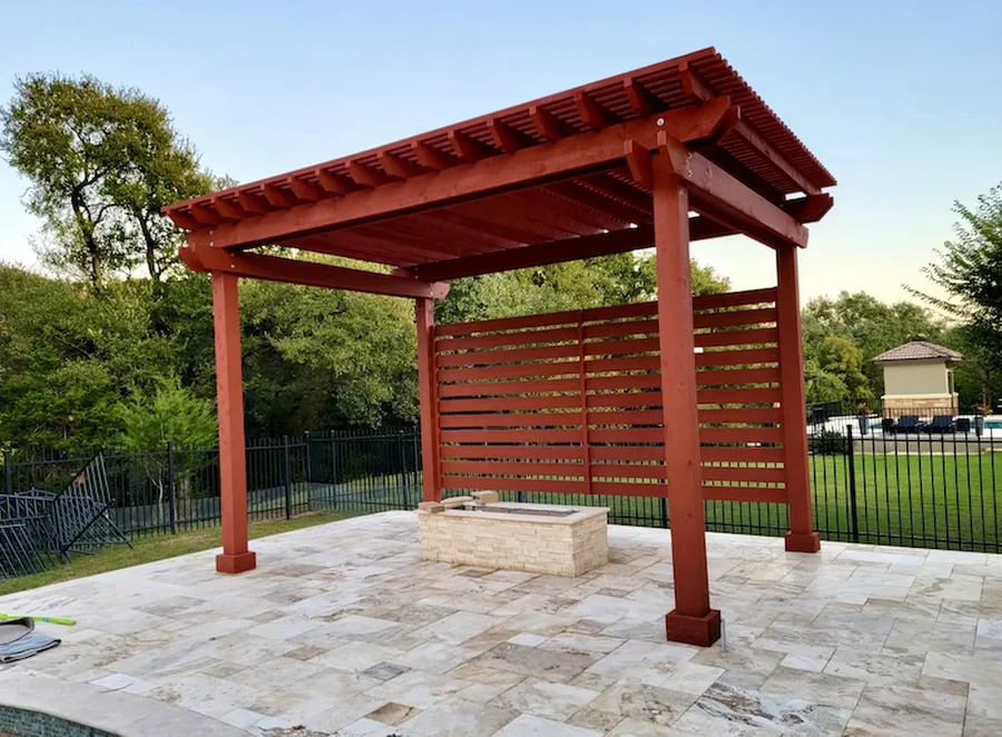 Freestanding cedar pergola with custom red stain and cedar privacy wall