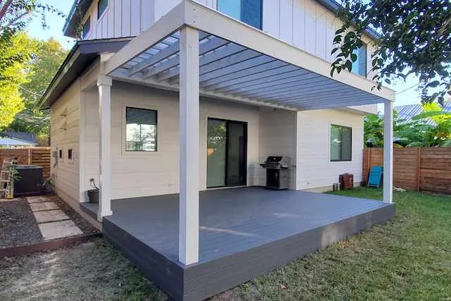 Modern attached pergola with solid white stain to match the home, with a Trex composite deck