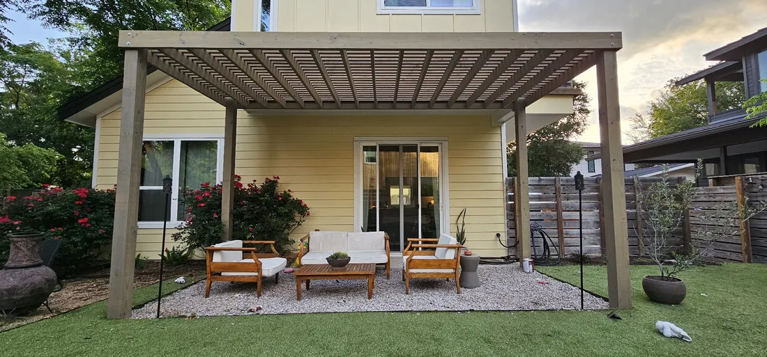Modern pergola with a privacy wall over a turf patio
