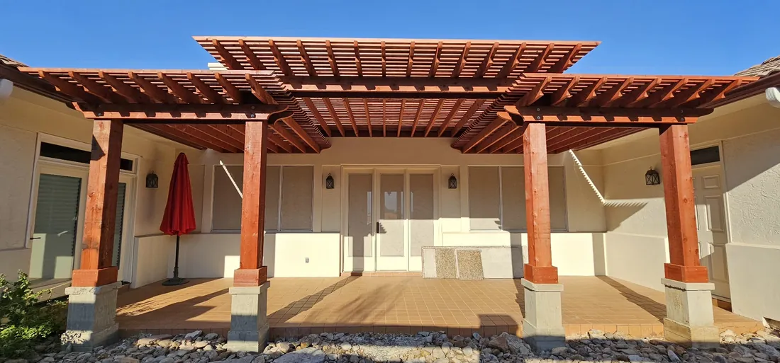 Large multi-level red-stained pergola attached to a stucco home