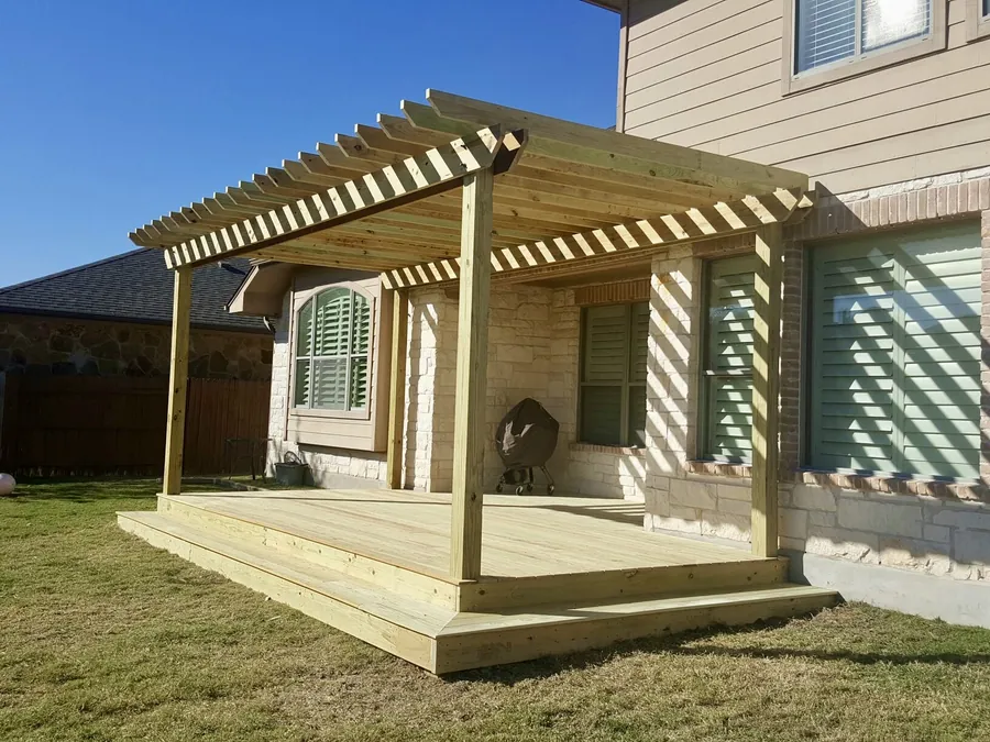 Unstained treated pine pergola and deck with a wrap-around step, ready for stain