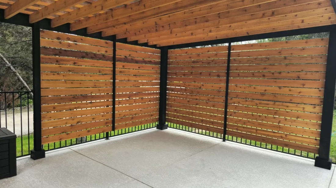 Two-tone stained cedar pergola with a two-sided corner privacy wall